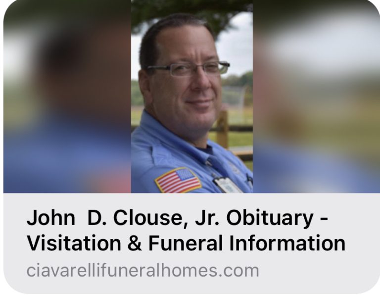 A man in a blue uniform with an American flag patch is pictured outdoors. Text below reads: "John D. Clouse, Jr. Obituary - Visitation & Funeral Information, ciavarellifuneralhomes.com.