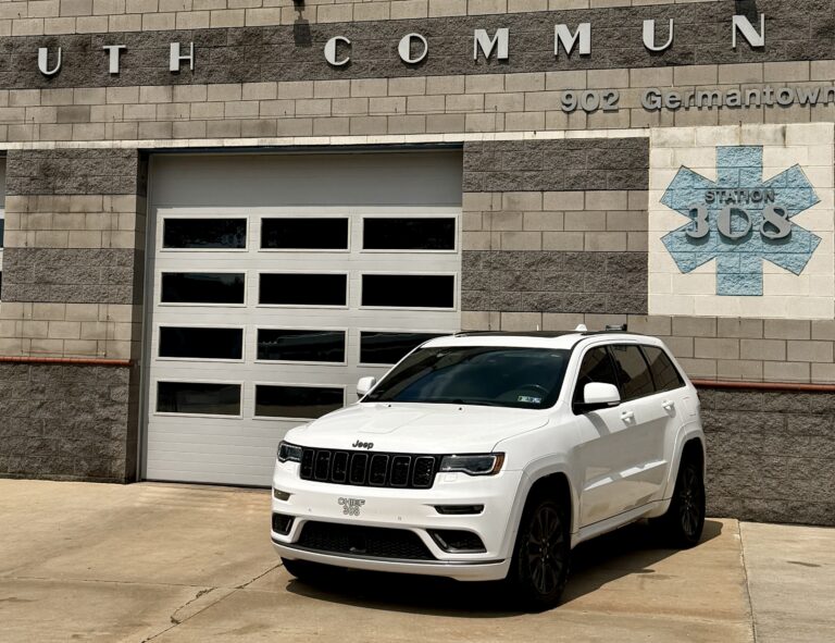 A white Jeep SUV is parked in front of a brick building with a garage door. The building has “Station 35” signage and is labeled “902 Germantown.”.