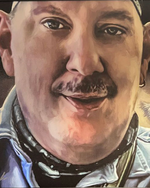 A painted portrait of a middle-aged man with a mustache, wearing a bandana, denim jacket, and scarf, looking directly at the viewer with a slight smile.
